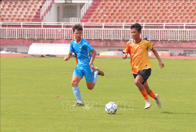 Cầu thủ U14 Thăng Long FC (áo vàng) đi bóng qua đối thủ U14 Gia Định FC (áo xanh). Ảnh: Trung Tuyến - TTXVN