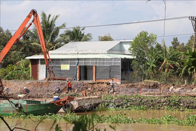 Xử lý điểm sạt lở bờ Đông sông Ba Rày. Ảnh: Minh Trí - TTXVN