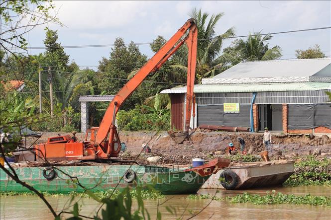 Xử lý điểm sạt lở bờ Đông sông Ba Rày. Ảnh: Minh Trí - TTXVN