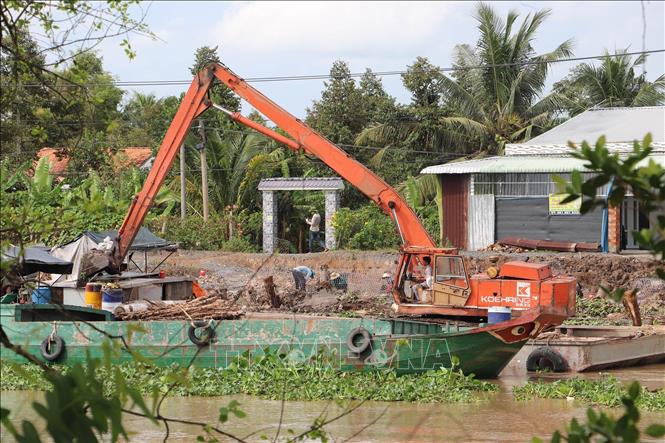 Xử lý điểm sạt lở bờ Đông sông Ba Rày. Ảnh: Minh Trí - TTXVN