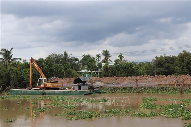 Xử lý điểm sạt lở bờ Đông sông Ba Rày. Ảnh: Minh Trí - TTXVN