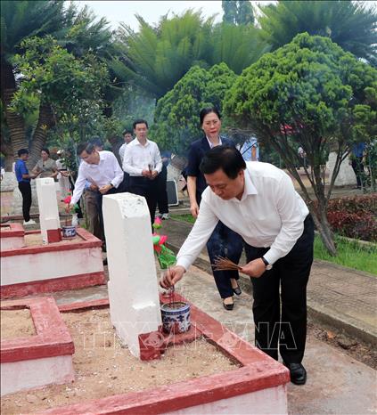 Đồng chí Nguyễn Xuân Thắng thắp hương trên phần mộ liệt sĩ tại Nghĩa trang liệt sĩ phường Cẩm Thành. Ảnh: Cao Nguyên-TTXVN
