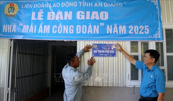 Chủ tịch Liên đoàn Lao động tỉnh An Giang Đỗ Trần Thịnh gắn biển “Mái ấm Công đoàn” cho đoàn viên Hứa Văn Phước. Ảnh: Lê Huy Hải - TTXVN