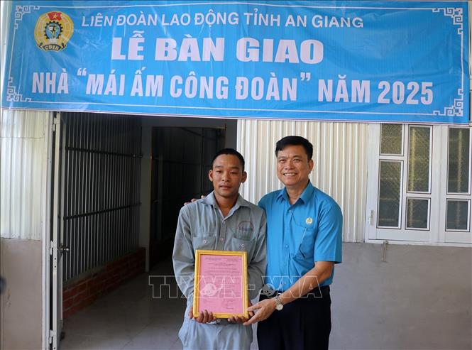 Chủ tịch Liên đoàn Lao động tỉnh An Giang Đỗ Trần Thịnh trao quyết định bàn giao “Mái ấm Công đoàn” cho đoàn viên Hứa Văn Phước. Ảnh: Lê Huy Hải - TTXVN