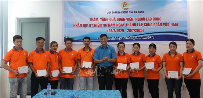 Chủ tịch Liên đoàn Lao động tỉnh An Giang Đỗ Trần Thịnh tặng quà cho đoàn viên Công đoàn cơ sở Công ty TNHH Huy Nam. Ảnh: Lê Huy Hải - TTXVN