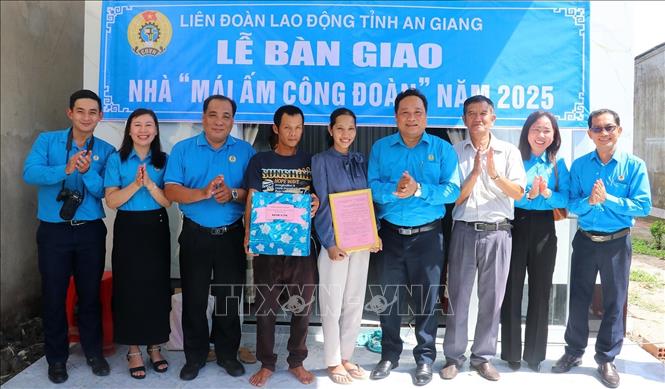 Lãnh đạo Liên đoàn Lao động tỉnh trao quyết định bàn giao “Mái ấm Công đoàn” cho đoàn viên Mai Thị Thiệu. Ảnh: Lê Huy Hải - TTXVN