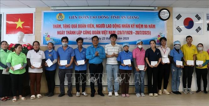 Phó Chủ tịch Liên đoàn Lao động tỉnh An Giang Phạm Văn Đằng tặng quà cho đoàn viên Công đoàn cơ sở Công ty TNHH Hwaseung Rạch Giá. Ảnh: Lê Huy Hải - TTXVN