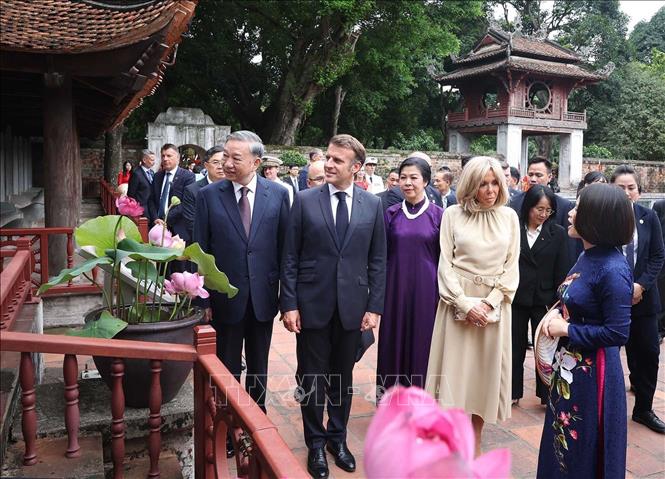 Tổng Bí thư Tô Lâm và Phu nhân cùng Tổng thống Pháp Emmanuel Macron và Phu nhân nghe giới thiệu về 82 bia tiến sĩ đã được UNESCO vinh danh là “Di sản tư liệu thế giới”. Ảnh: Thống Nhất – TTXVN