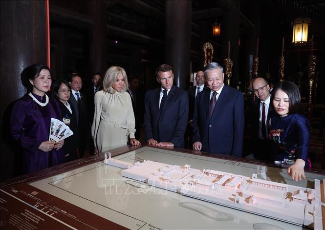 Tổng Bí thư Tô Lâm và Phu nhân cùng Tổng thống Emmanuel Macron và Phu nhân nghe giới thiệu về kiến trúc đặc trưng và ý nghĩa lịch sử của Văn Miếu - Quốc Tử Giám. Ảnh: Thống Nhất – TTXVN