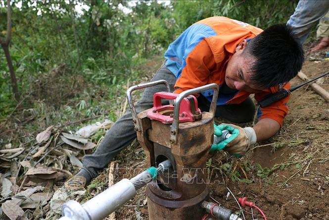 Công nhân cố định đầu cáp để chuẩn bị kéo cáp lên cột ở vị trí cột số 18, thuộc địa bàn xã Xuân Quang, tỉnh Lào Cai. Ảnh: Vũ Sinh - TTXVN
