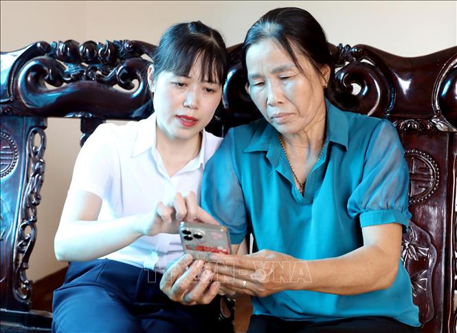 Đảng viên cảnh báo và hướng dẫn người dân để phòng, tránh những chiêu trò lừa đảo qua mạng. Ảnh: Thế Duyệt – TTXVN