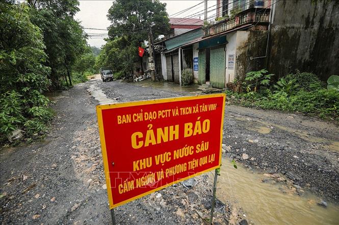 Biển cảnh báo được đặt tại điểm ngập lụt trên con đường liên xã từ xóm Nước vải đi Xóm Rụt, xã Tân Vinh. Ảnh: Trọng Đạt - TTXVN
