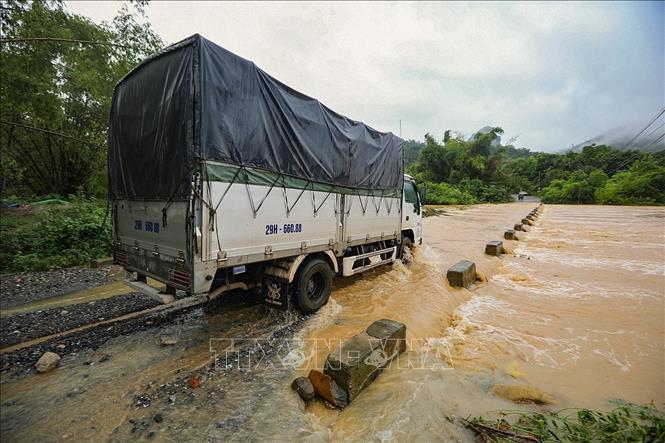 Một ô tô tải bất chấp nguy hiểm đi qua ngầm tràn khi nước đổ lũ về trên địa phận xã Lương Sơn. Ảnh: Trọng Đạt - TTXVN