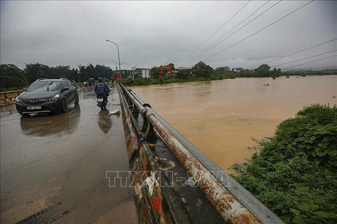 Nước lũ dâng cao tại xã Nhuận Trạch đoạn cầu Bãi Sỏi lưu thông ra Quốc lộ 6. Ảnh: Trọng Đạt - TTXVN