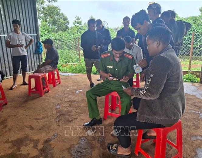 Cán bộ Công an xã Anh Phú, tỉnh Gia Lai, hướng dẫn người dân thực hiện thủ tục hành chính trên điện thoại thông minh. Ảnh: Hoài Nam – TTXVN