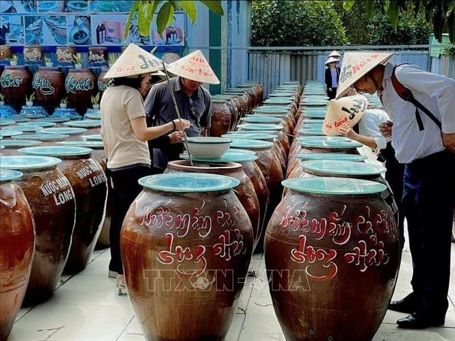 Khách tham quan khu vực phơi nước mắm của Công ty TNHH Sản xuất – Thương mại và Dịch vụ Hati, xã Phước Hải, TP. Hồ Chí Minh. Ảnh: Hoàng Nhị - TTXVN