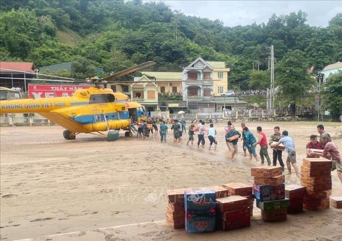 A helicopter bringing relief goods to flood-affected areas in Nghe An. VNA/Photo by courtesy