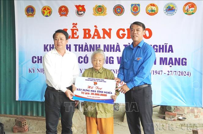 Đại diện lãnh đạo Đảng ủy Khối, Đoàn Khối các cơ quan tỉnh Quảng Bình trao biển hỗ trợ kinh phí xây nhà cho gia đình bà Lê Thị Nhung (SN 1947) từng tham gia kháng chiến chống Mỹ cứu nước, là thương bệnh binh. Ảnh: TTXVN phát