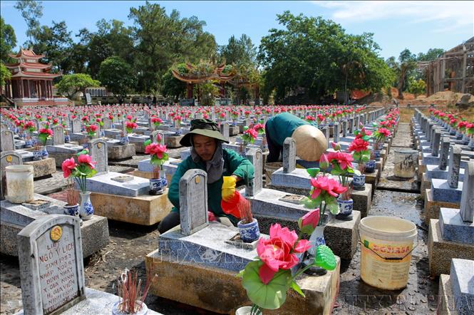 Người dân trên địa bàn tỉnh Quảng Trị vệ sinh làm sạch các phần mộ liệt sỹ tại Nghĩa trang liệt sỹ Quốc gia Trường Sơn. Ảnh: Hồ Cầu – TTXVN