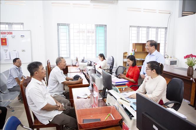 Phó Chủ tịch UBND tỉnh Tây Ninh Nguyễn Hồng Thanh (đứng bên phải) lắng nghe ý kiến của nhân dân đến làm thủ tục hành chính tại Trung tâm phục vụ Hành chính công xã Tân Đông. Ảnh: Giang Phương - TTXVN