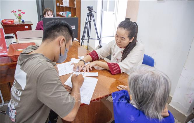Người dân được cán bộ Trung tâm phục vụ Hành chính công xã Tân Đông hướng dẫn các thủ tục hành chính. Ảnh: Giang Phương – TTXVN
