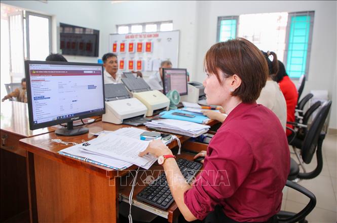 Cán bộ Trung tâm phục vụ Hành chính công xã Tân Đông thực hiện quy trình giải quyết thủ tục hành chính trên các hệ thống phần mềm. Ảnh: Giang Phương - TTXVN