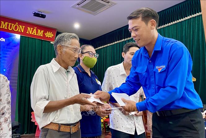 Bí thư Đoàn Ủy ban nhân dân tỉnh Quảng Trị Nguyễn Tuấn Hùng trao quà cho các thương binh, bệnh binh, cựu chiến binh. Ảnh: Võ Dung - TTXVN