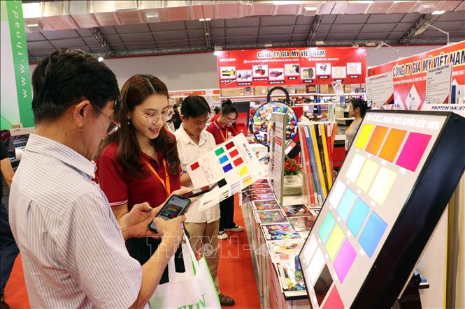 Khách tham quan tìm hiểu về sản phẩm được trưng bày tại triển lãm. Ảnh: Tiến Lực - TTXVN