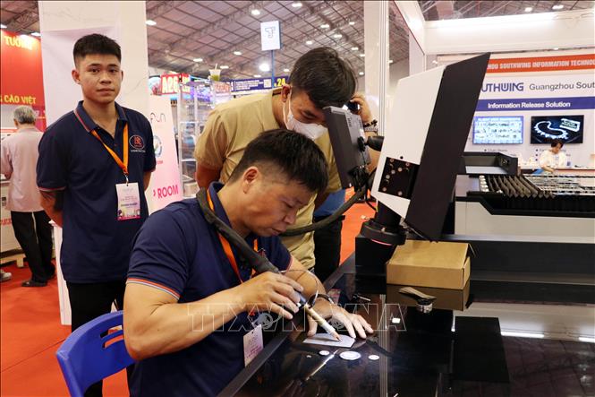 Khách tìm hiểu công nghệ được trưng bày và giới thiệu tại Tuần lễ. Ảnh: Tiến Lực - TTXVN