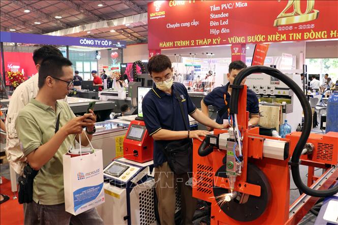 Khách tìm hiểu công nghệ được trưng bày và giới thiệu tại Tuần lễ. Ảnh: Tiến Lực - TTXVN