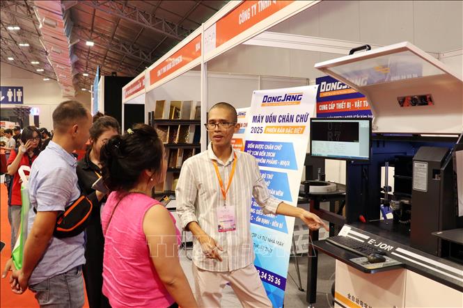 Khách tham quan tìm hiểu về sản phẩm được trưng bày tại triển lãm. Ảnh: Tiến Lực - TTXVN