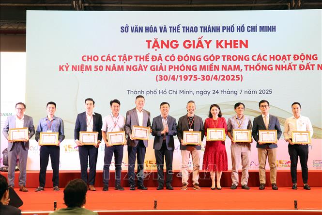 Tăng giấy khen cho các tập thể có đóng góp trong các hoạt động Kỷ niệm 50 năm Giải phóng miền Nam, thống nhất đất nước (30/4/1975 - 30/4/2025) tại Lễ khai mạc. Ảnh: Tiến Lực - TTXVN