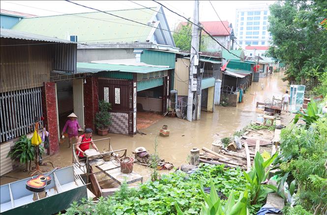 Người dân xã Con Cuông, tỉnh Nghệ An dọn nhà cửa, đồ đạc, vật dụng và môi trường cảnh quang khu dân cư khi nước lũ giảm mạnh. Ảnh: Xuân Tiến - TTXVN 