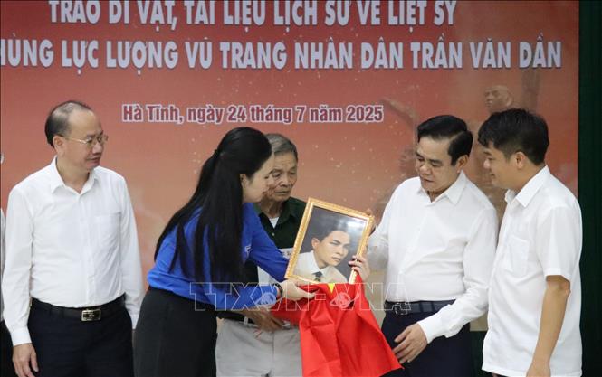 Lãnh đạo tỉnh Hà Tĩnh cùng trao tặng các kỷ vật, tài liệu lịch sử và di ảnh phục dựng của liệt sĩ cho thân nhân gia đình. Ảnh: Hoàng Ngà - TTXVN