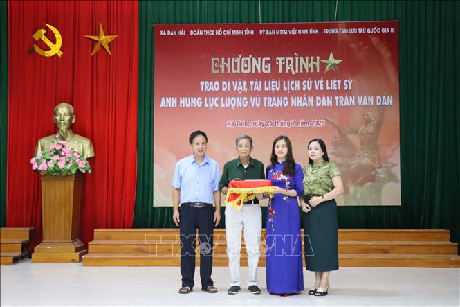 Trung tâm Lưu trữ Quốc gia III trao lại tư liệu lịch sử về Anh hùng LLVTND liệt sĩ Trần Văn Dần cho thân nhân gia đình. Ảnh: Hoàng Ngà - TTXVN