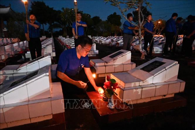 Bí thư Tỉnh đoàn An Giang Phan Duy Bằng cùng đoàn viên, thanh niên thắp nến tại các phần mộ liệt sĩ
Ảnh: Văn Sĩ - TTXVN