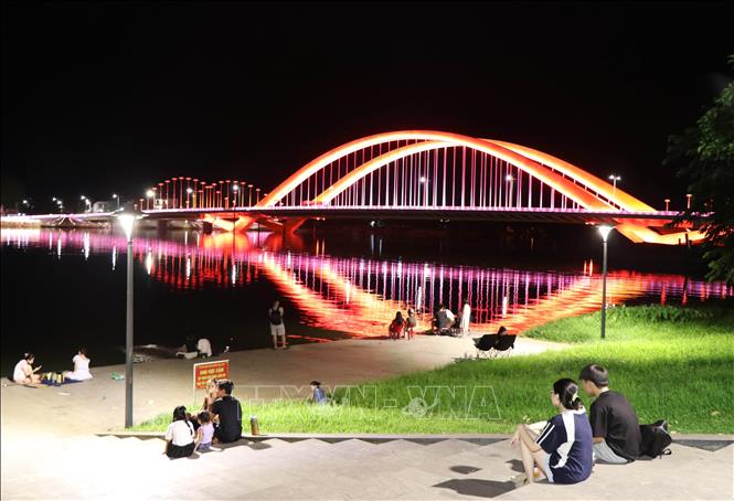Visitors admiring the architectural beauty of Nguyen Hoang Bridge at night. VNA Photo: Nguyên Lý