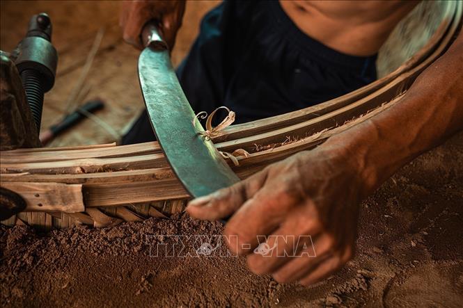 Các công đoạn để làm nên một chiếc thúng từ chọn tre, chẻ tre, vót tre đến đan mên, lận, nức… đều được người thợ làm thủ công, tỉ mỉ. Ảnh: Khánh Hòa – TTXVN 