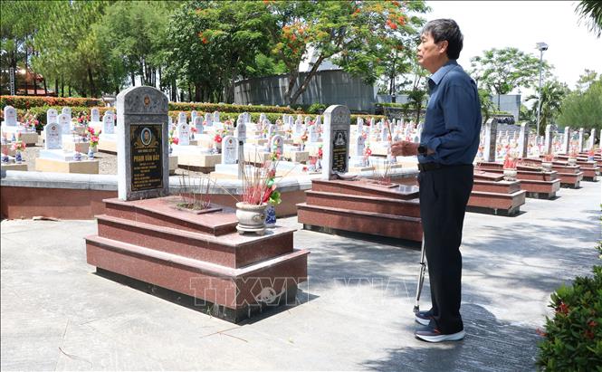 Cựu chiến binh Nguyễn Hà (76 tuổi, thành phố Hải Phòng) thắp hương cho đồng đội ở Nghĩa trang Liệt sĩ Quốc gia Đường 9. Ảnh: Tường Vi - TTXVN
