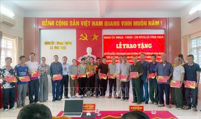 Trao tặng cờ Tổ quốc cho nhân dân xã đảo Vĩnh Thực. Ảnh: TTXVN phát