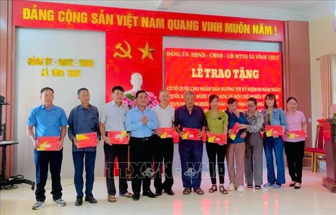 Trao tặng cờ Tổ quốc cho nhân dân xã đảo Vĩnh Thực. Ảnh: TTXVN phát