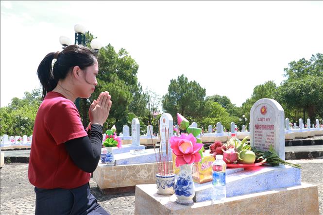 Chị Nguyễn Thị Liên (Hà Nội) viếng và thắp hương tưởng nhớ ông ngoại là liệt sĩ Phùng Minh Chung tại Nghĩa trang Liệt sĩ Quốc gia Đường 9. Ảnh: Tường Vi - TTXVN 