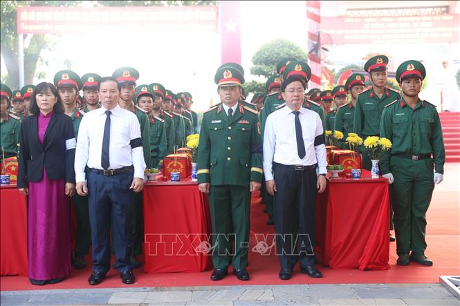Bí thư Tỉnh ủy Tây Ninh Nguyễn Văn Quyết (áo trắng bìa phải) và Chủ tịch UBND tỉnh Tây Ninh Nguyễn Văn Út (áo trắng bìa trái) thực hiện nghi thức Di quan hài cốt liệt sĩ ra phần mộ để an táng. Ảnh: Thanh Tân - TTXVN