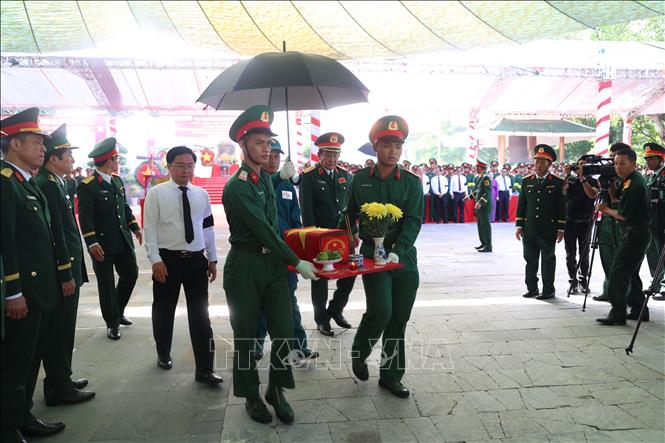 Lãnh đạo Bộ Quốc phòng, lãnh đạo Tỉnh ủy thực hiện nghi thức Di quan hài cốt liệt sĩ ra phần mộ để an táng. Ảnh: Thanh Tân - TTXVN