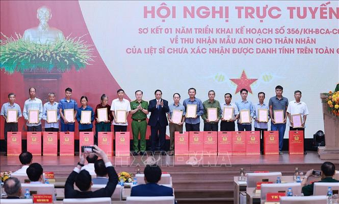Thủ tướng Phạm Minh Chính trao thông báo kết quả giám định ADN hài cốt liệt sĩ cho đại diện gia đình liệt sĩ. Ảnh: Dương Giang-TTXVN
