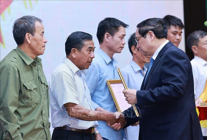 Thủ tướng Phạm Minh Chính trao thông báo kết quả giám định ADN hài cốt liệt sĩ cho đại diện gia đình liệt sĩ. Ảnh: Dương Giang-TTXVN
