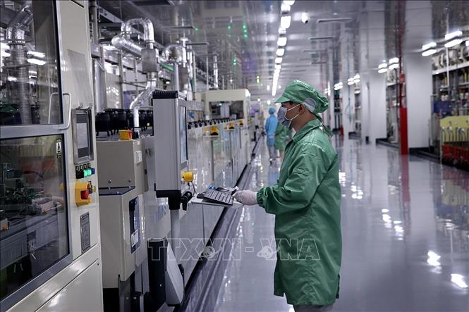 Công nhân điều hành công việc tại nhà máy Meiko. Ảnh: Thanh Hải - TTXVN