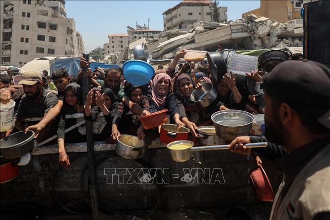 Người dân Palestine chờ nhận thức ăn cứu trợ tại thành phố Gaza, ngày 24/7/2025. Ảnh: THX/TTXVN