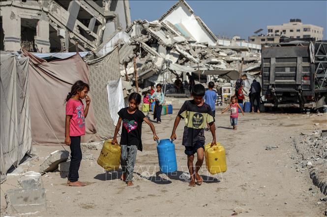 Trẻ em Palestine đi lấy nước về sinh hoạt tại khu vực Sheikh Radwan, thành phố Gaza, ngày 17/7/2025. Ảnh: THX/TTXVN
