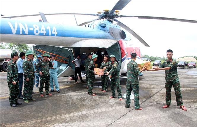 Lực lượng cứu trợ vận chuyển mì tôm, lương khô, nước.... lên trực thăng để chuyển đến các xã đang bị cô lập. Ảnh: Văn Tý-TTXVN